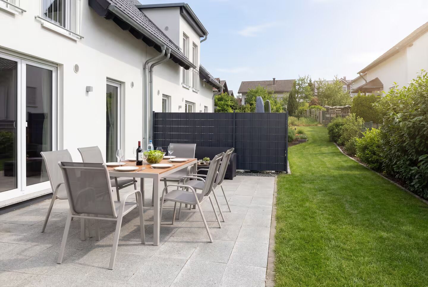 Geschützte Terrasse mit Esstisch und Gartenblick